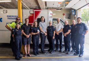 David Eby with Roly Russell and emergency staff in front of an ambulance in Grand Forks